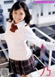 A young woman in a school uniform posing for a picture.