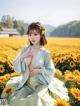 A woman in a blue dress sitting in a field of sunflowers.