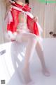 A woman in a red and white lingerie sitting on a bathtub.