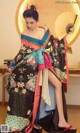 A woman in a kimono holding a fan in her hand.