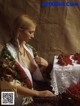 A woman sitting at a table with a basket of red currants.