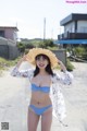 A woman in a blue bikini and a straw hat.