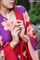 A woman in a purple and pink kimono is posing for a picture.