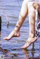 A woman's bare feet in the water on a boat.