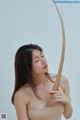 A woman holding a wooden bow and arrow in her hand.